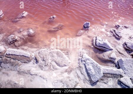 Salty Pink lake shore. Stones covered with salt. Nature background Stock Photo