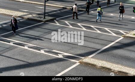 LISBON, PORTUGAL - Dec 15, 2020: People crossing a street on a zebra crossing in front of the Vasco da Gama shopping Mall Stock Photo