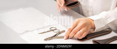 Le mani del manicure posano giù gli attrezzi di manicure sulla tabella che prepara per procedure di manicure Foto Stock