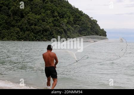 Pescatore uomo gettando rete di pesca per la cattura di pesce per cibo Foto Stock