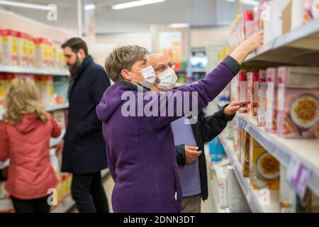 Coppia che indossa una maschera protettiva nel supermercato Foto Stock