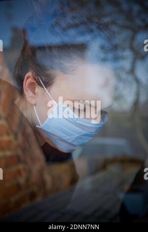 Donna che indossa la maschera protettiva Foto Stock