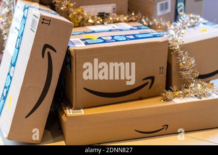 Pacchetti Amazon depositati ai piedi dell'albero di Natale Foto Stock