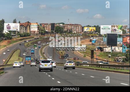 Veicoli che guidano sull'autostrada di Thika con traffico ed edifici, Nairobi, Kenia Foto Stock