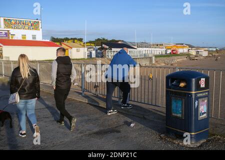 GRAN BRETAGNA / Galles /Porthcawl / Peopel camminando verso i portici di Coney Beach e il parco divertimenti sul lungomare . Foto Stock