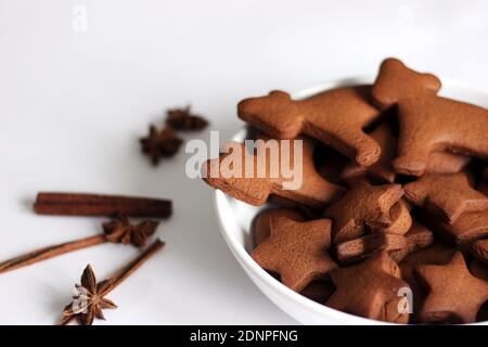 Piatto di biscotti di pan di zenzero di Natale su sfondo bianco con spezie. Foto Stock