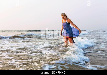 Donna in piedi in mare Foto Stock