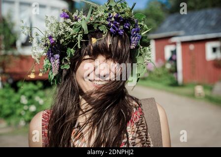 Donna felice che indossa la corona di fiori Foto Stock