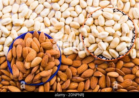 Mandorle e nocciole nella ciotola, birra e snack sano, vista ad angolo alto Foto Stock