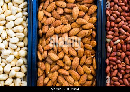 Mandorle, arachidi e nocciole nella ciotola, birra e snack sano, vista ad angolo alto Foto Stock