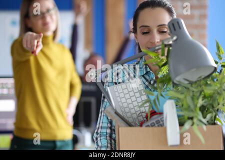 Donna che trasporta la scatola degli effetti personali in ufficio Foto Stock