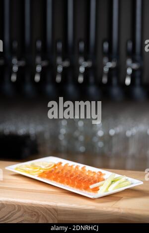 Menu del ristorante. Piatto con salmone leggermente salato e affumicato su sfondo di tavola di legno. Spazio di copia. Menu per la birra nel ristorante Foto Stock