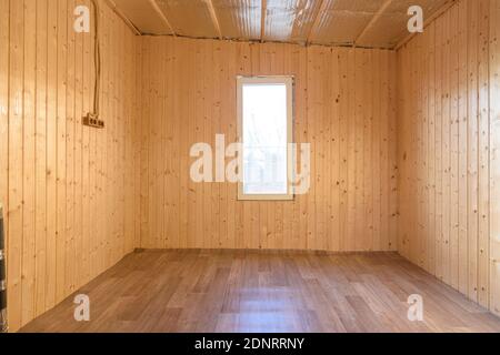 L'interno di una piccola stanza vuota in una casa di campagna, le pareti sono clapboard, linoleum è posato sul pavimento Foto Stock