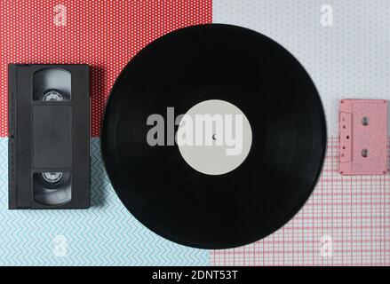 Videocassetta, vinile, audiocassetta su sfondo creativo, vista dall'alto Foto Stock