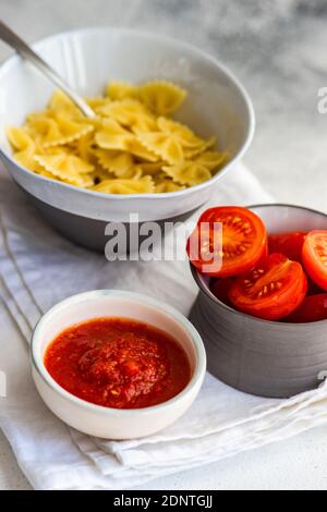 Pasta fresca di farfalle con salsa di pomodoro e pomodori freschi il lato Foto Stock