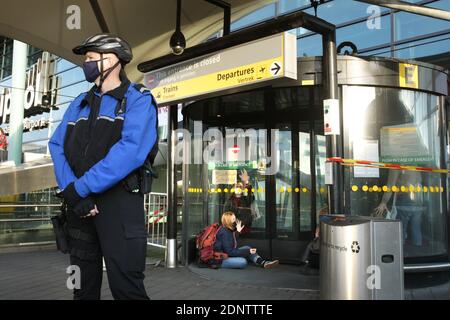 Estinzione ribellione attivisti ambientali finzione le mani con super colla sul vetro della porta durante la protesta blocca l'accesso dei terminali dell'aeroporto di Schiphol Amsterdam in mezzo alla pandemia di coronavirus il 18 dicembre 2020 ad Amsterdam, Paesi Bassi. I manifestanti ambientali della ribellione per l'estinzione fanno una dimostrazione contro il governo e la posizione eccezionale dell'aviazione dello Schiphol, si risparmiano le misure di blocco, si consente di superare le norme sull'azoto, non è necessario richiedere permessi ambientali; e può continuare a crescere sono nel bel mezzo di una crisi climatica. Kerosen Foto Stock