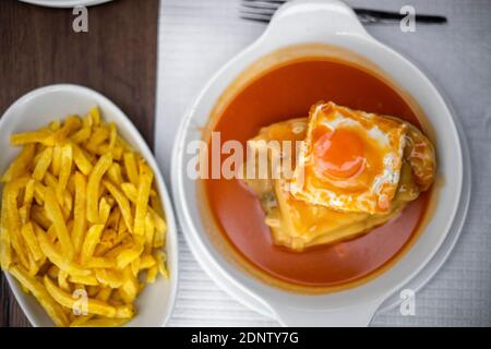 Famoso cibo tradizionale di Porto chiamato francesinha con patatine fritte, Portogallo Foto Stock