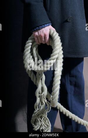 Primo piano di mano maschio che tiene la corda rope.Hemp in una mano di un uomo. Foto Stock