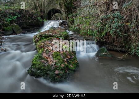 Flusso che scorre attraverso un ponte ad arco nella valle di Wye inferiore. Foto Stock