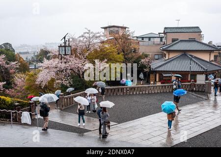 Kyoto, Giappone - Aprile 9, 2019: angolo alto vista di molte persone con ombrelloni a piedi da ingresso durante il giorno di pioggia a Kiyomizu-dera tempio Foto Stock