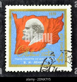 Francobollo annullato stampato dall'Unione Sovietica, che mostra Lenin e bandiera rossa, circa 1970. Foto Stock