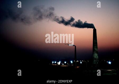 DHAKA, BANGLADESH – 18 dicembre 2020: Inquinamento atmosferico, il camino di una fabbrica di mattoni scarica il fumo al mattone archiviato ad Amin bazar, saver Dhaka. S Foto Stock