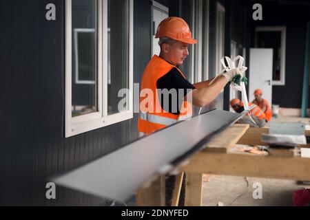 Gli installatori lavorano all'installazione di blocchi di finestre nel cantiere di un centro di soccorso medico. Foto Stock