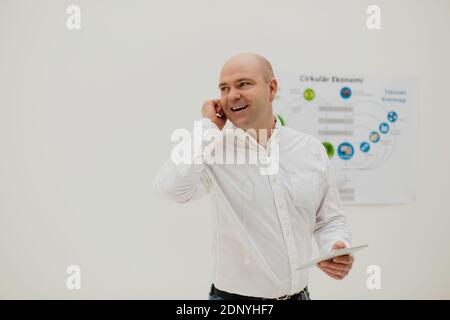 Imprenditore sorridente sul telefono Foto Stock