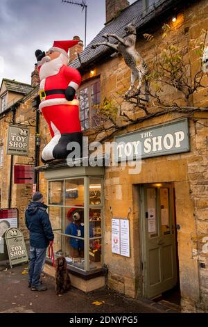 Regno Unito, Gloucestershire, Moreton in Marsh, High Street, gonfiabile Natale del padre fuori negozio di giocattoli Foto Stock