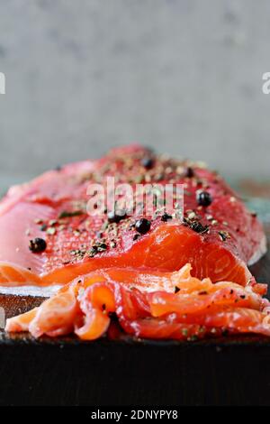 Gravlax, salmone speziato stagionato di barbabietola scandinava sulla tavola, pesce rosso salato Foto Stock