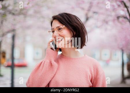 Donna sorridente parlando via telefono cellulare Foto Stock