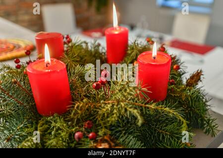 Tre candele che bruciano sulla ghirlanda dell'avvento in tempo pre-natalizio a. cucina domestica Foto Stock