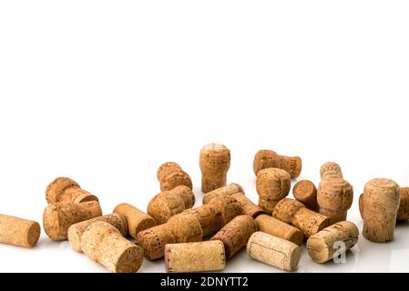 I tappi di vino usati sparsi casualmente riempiono le metà cornici su sfondo bianco, spazio per il testo, isolato su bianco Foto Stock