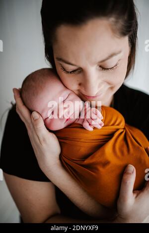 Madre abbracciando neonato bambino Foto Stock