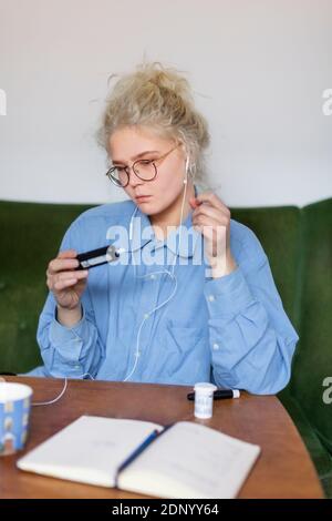 Giovane donna che usa il glucometro Foto Stock