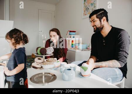 Ragazza che ha una festa del tè con i genitori Foto Stock