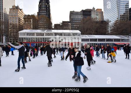 Folla di persone sulla pista di pattinaggio su ghiaccio di Bryant Park Winter Village durante le vacanze a New York City Foto Stock