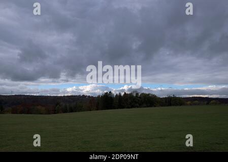 Oscuro strato di nuvole sopra il paesaggio rurale con turbine eoliche, Baviera, Germania Foto Stock