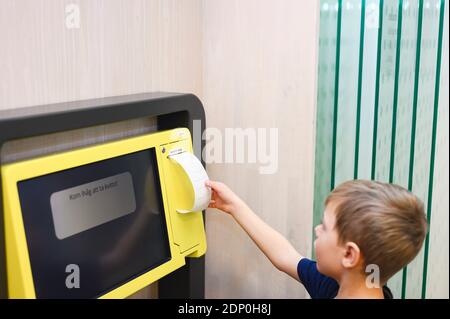 Ragazzo che usa un punto self-service nella libreria Foto Stock