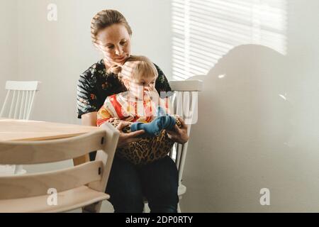 Figlia seduti sulle madri lap Foto Stock