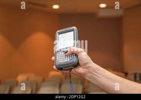 Donna che mantiene Portable Barcode Scanner dispositivo lettore Foto Stock