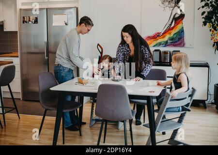 Donne con due figlie a tavola Foto Stock