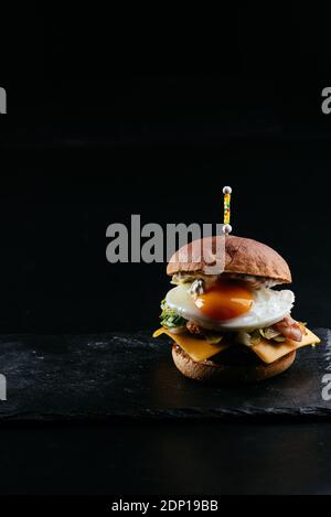 Hamburger, patate, salsa su fondo nero Foto Stock