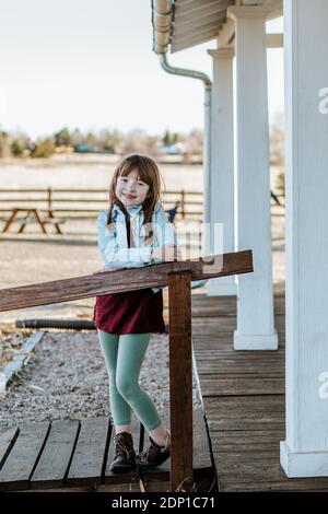 Felice giovane ragazza in piedi sul patio sorridente su un sole giorno Foto Stock