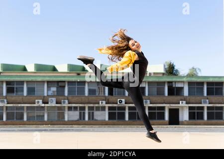 Felice ragazza adolescente jumping all'aperto Foto Stock