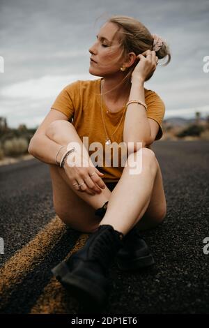 Donna seduta su una strada, Joshua Tree National Park, California, Stati Uniti d'America Foto Stock