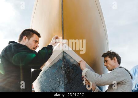 Uomo adesivo nastro di mascheratura sulla barca Foto Stock