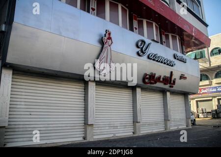 18 dicembre 2020: Striscia di Gaza, Palestina. 18 dicembre 2020. Le strade sono quasi deserte mentre le imprese rimangono chiuse nella striscia di Gaza settentrionale, poiché venerdì è entrato in vigore un blocco di due giorni nell'enclave palestinese per frenare un'impennata di infezioni da Covid. Il Ministero degli interni palestinese ha imposto un blocco completo del venerdì e del sabato per ridurre i contatti e il sovraffollamento alla luce della recente impennata di casi di coronavirus nella striscia di Gaza, che ha 9,500 casi attivi e ha subito 200 decessi correlati a Covid. L'Agenzia delle Nazioni Unite per il soccorso e l'occupazione in Palestina Foto Stock