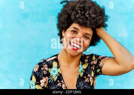 Ritratto di donna sorridente donna Afroamericana, mano nei capelli Foto Stock
