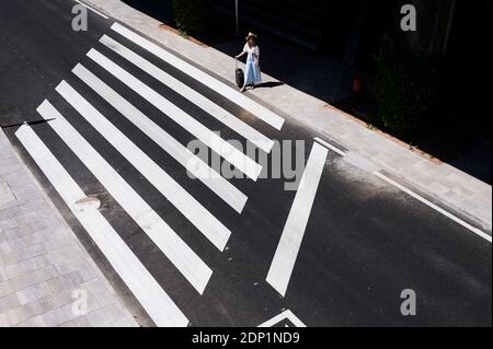 Vista superiore della giovane donna con il bagaglio di attraversare una via all'aeroporto Foto Stock